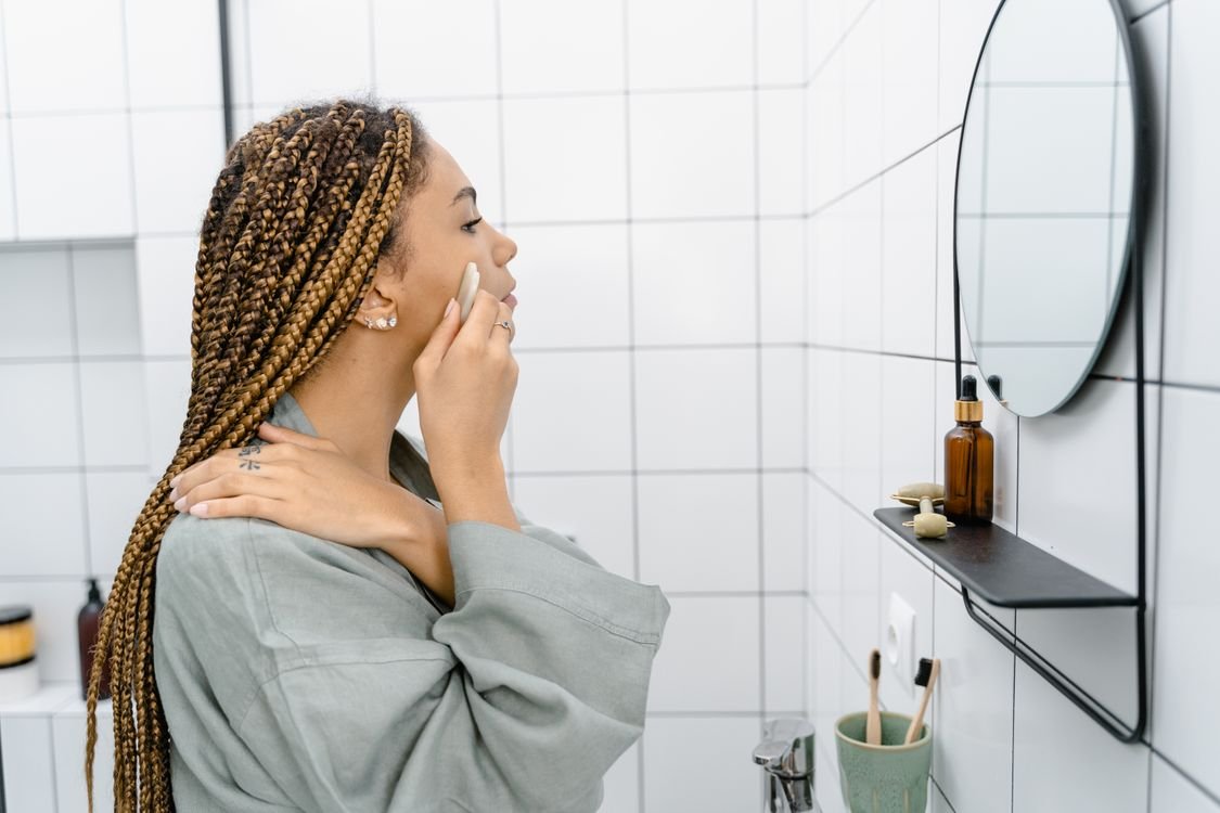 Woman doing her skincare routine in front of a mirror