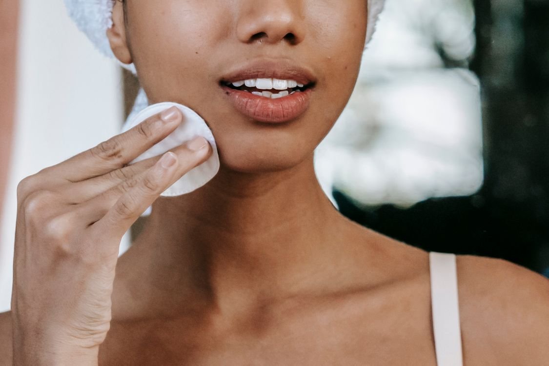 Close-up of a woman applying toner with a cotton pad