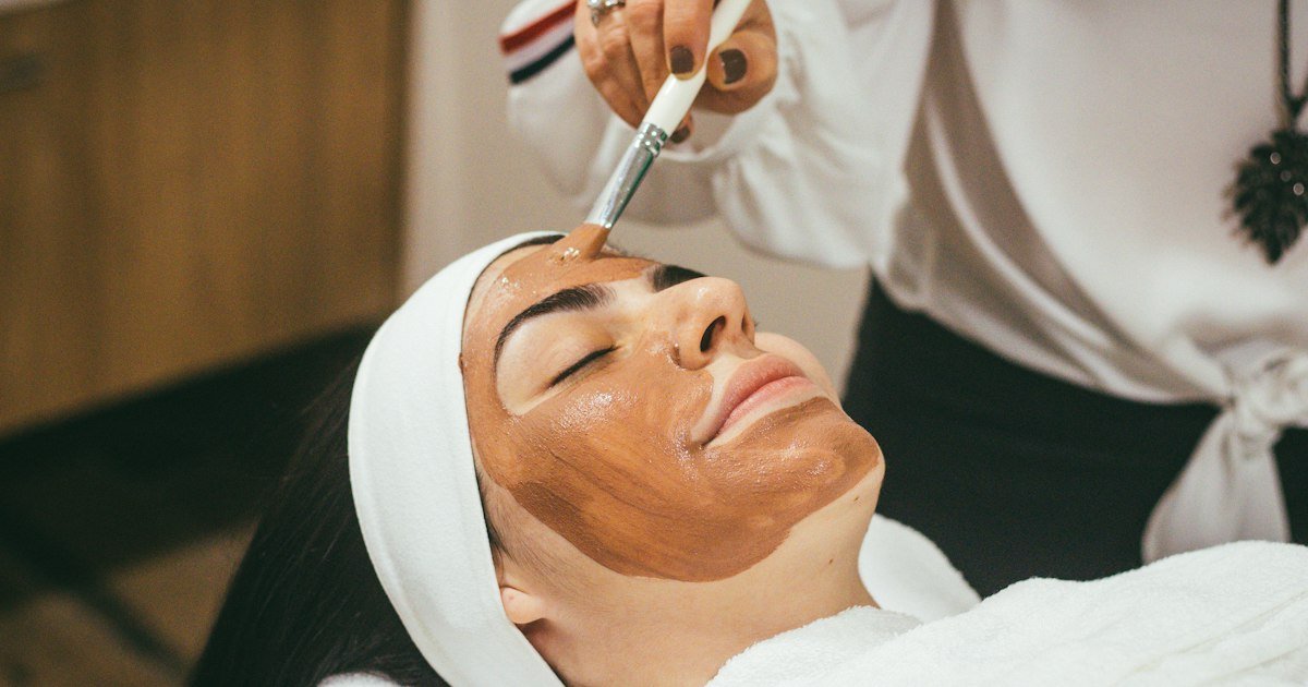 Woman with smooth, glowing skin applying skincare cream