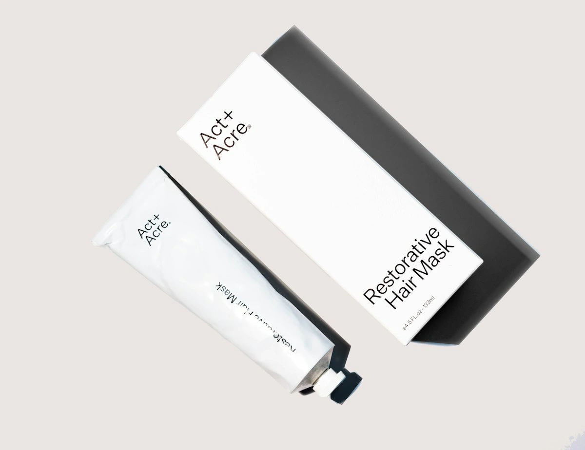 Minimalist white skincare bottles and tubes arranged on a clean surface