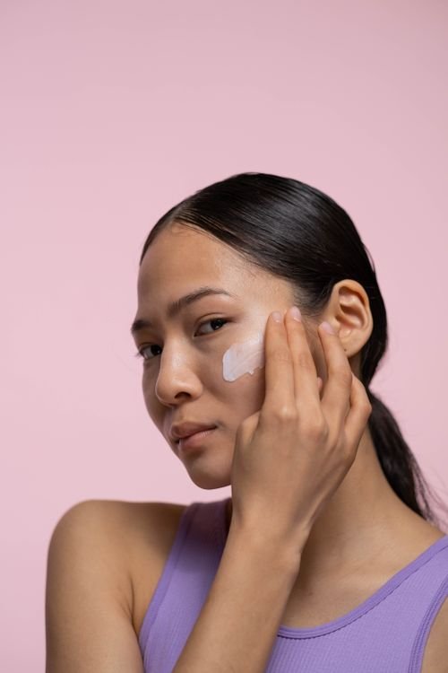 Woman applying face cream during her skincare routine